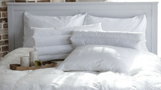 Bed with white sheets and breakfast tray.