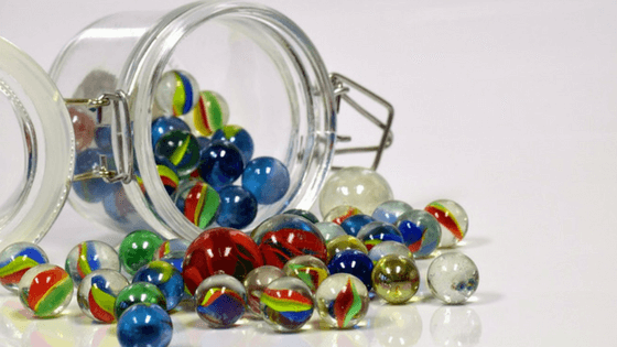 Place small toys in your kid's bedroom, in individual containers like these marbles in a jar.